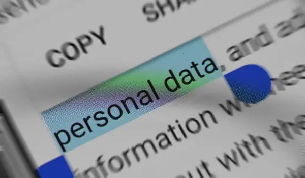 A magnifying glass is highlighting the words "personal data" on a document.